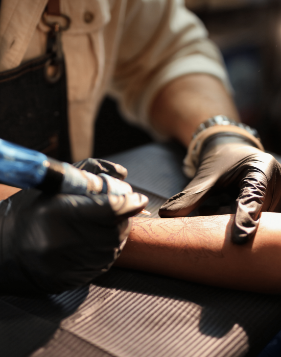 A man is getting a tattoo on his arm.